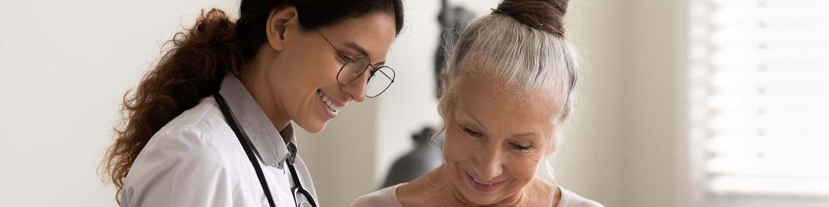 Eine Ärztin erklärt einer Frau etwas auf einem Tablet