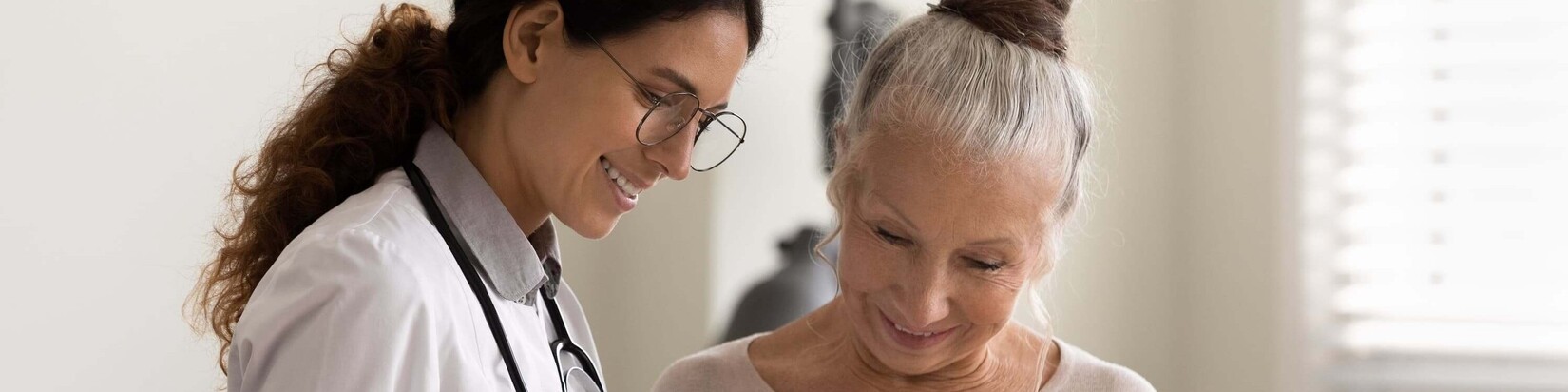 Eine Ärztin erklärt einer Frau etwas auf einem Tablet